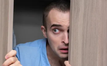 A man peeking through a door | Source: Shutterstock