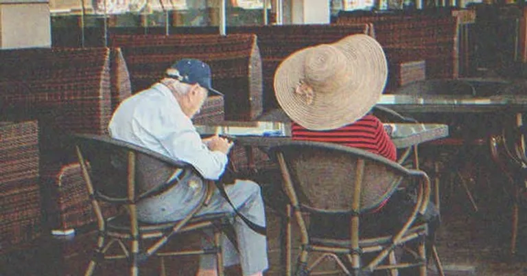 An old couple sitting at a table | Source: Shutterstock