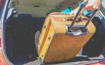 A person loading a suitcase into a car | Source: Shutterstock