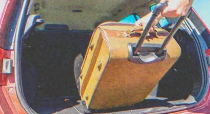 A person loading a suitcase into a car | Source: Shutterstock