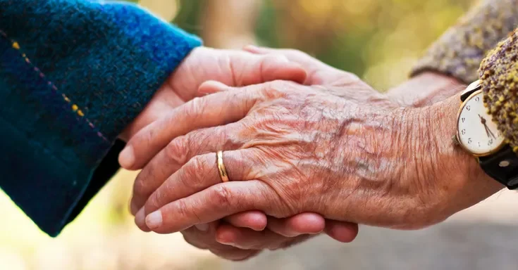 Elderly people holding hands | Source: Shutterstock