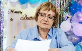 A woman holding a piece of paper at a birthday party | Source: Shutterstock