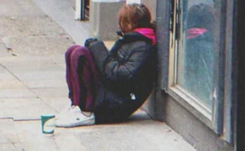 A young girl sitting on the street | Source: Shutterstock