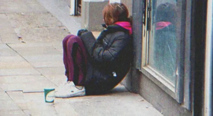 A young girl sitting on the street | Source: Shutterstock