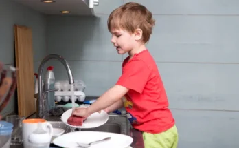 A boy washing dishes | Source: Shutterstock