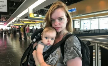 A woman holding a baby in an airport terminal | Source: Amomama