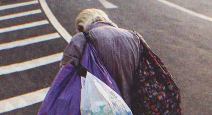 An old poor man walking down the street | Source: Shutterstock