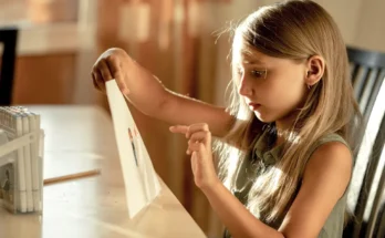 A girl holding a drawing | Source: Shutterstock