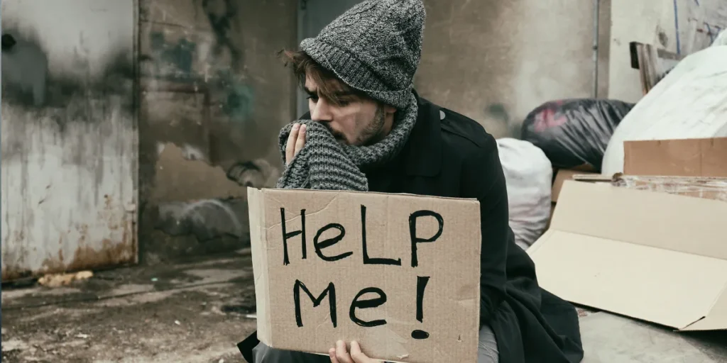 A homeless person with a sign | Source: Shutterstock