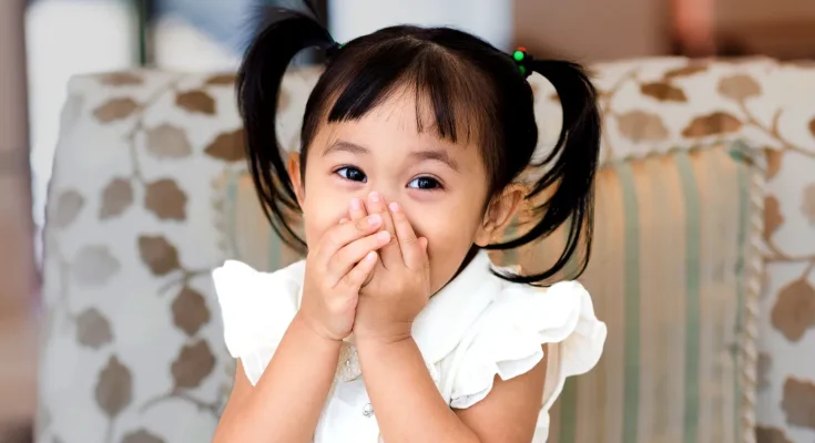 A girl sitting with her face covered | Source: Shutterstock