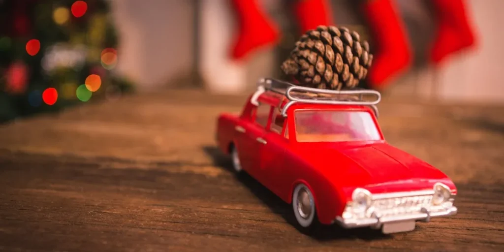 A toy car with a pine cone on the luggage rack | Source: Freepik