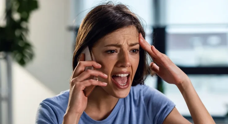 A shocked woman speaking on her phone | Source: Shutterstock