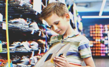 A boy looking at a pair of shoes | Source: Shutterstock