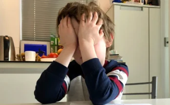 A boy covering his face with his hands | Source: Shutterstock