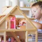 A boy playing with a dollhouse | Source: Shutterstock