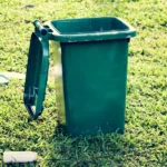 A bin and trash on a lawn | Source: Shutterstock