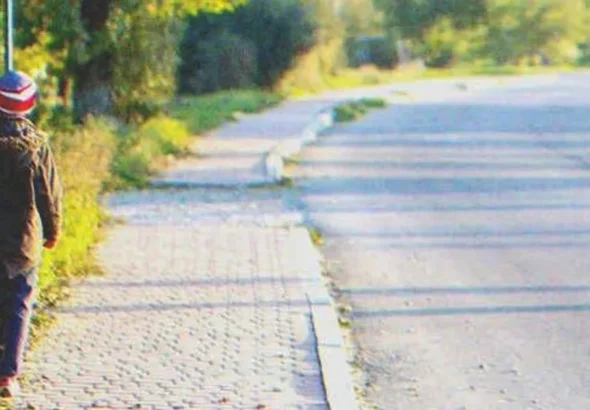 A kid walking down a street | Source: Shutterstock